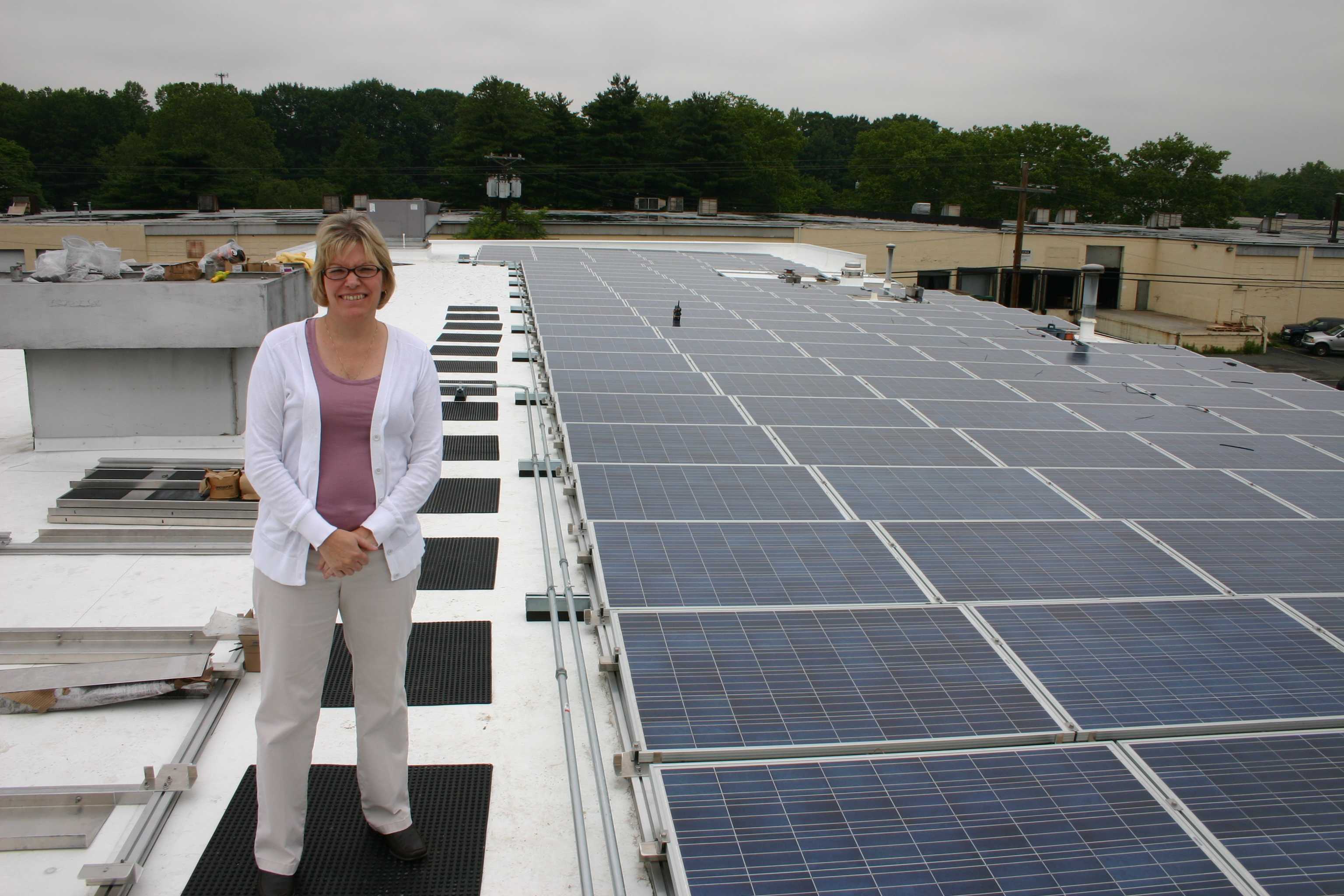 My wife Pam on the roof of our building.  Approximately 50% of our panels were installed at this point.