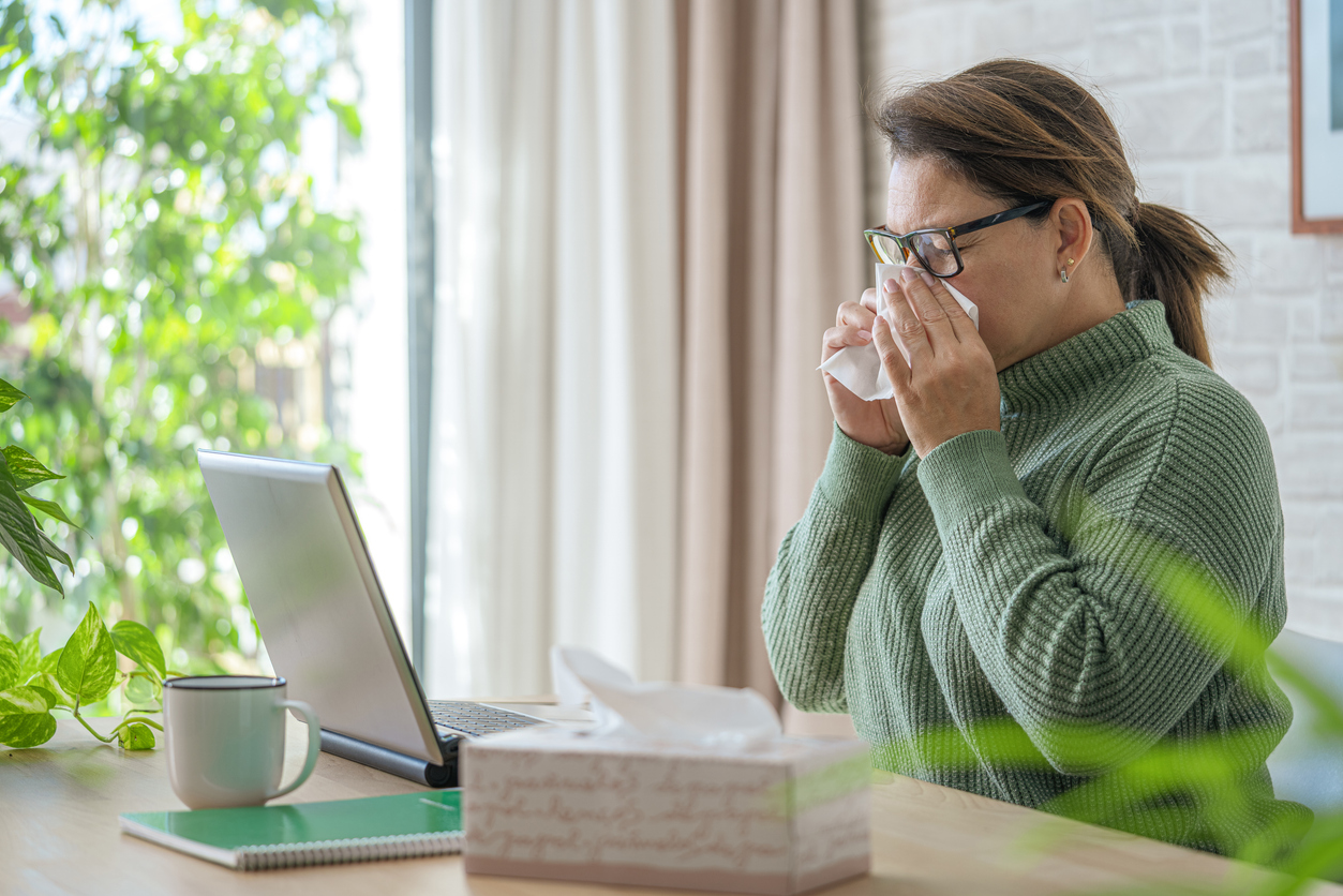 Woman sitting at computer sipping coffee